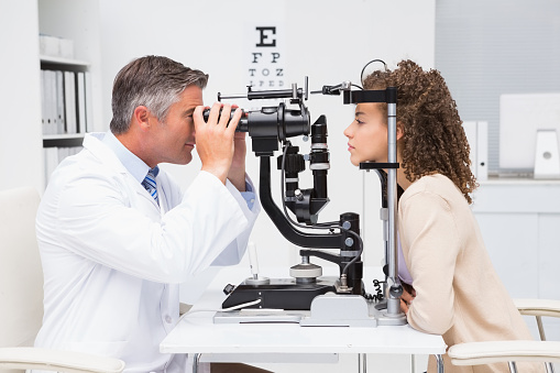 Woman doing eye test with optometrist in medical office, eye doctor Springfield MA, eye doctor east longmeadow MA, eye doctor Western MA