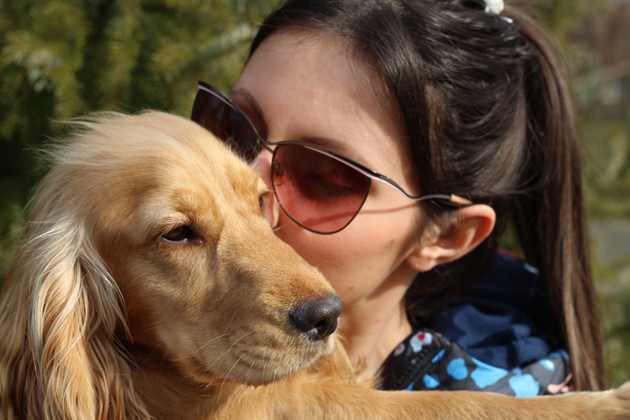 woman in sunglasses holding puppy